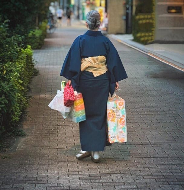 Japanese person walking holding bags