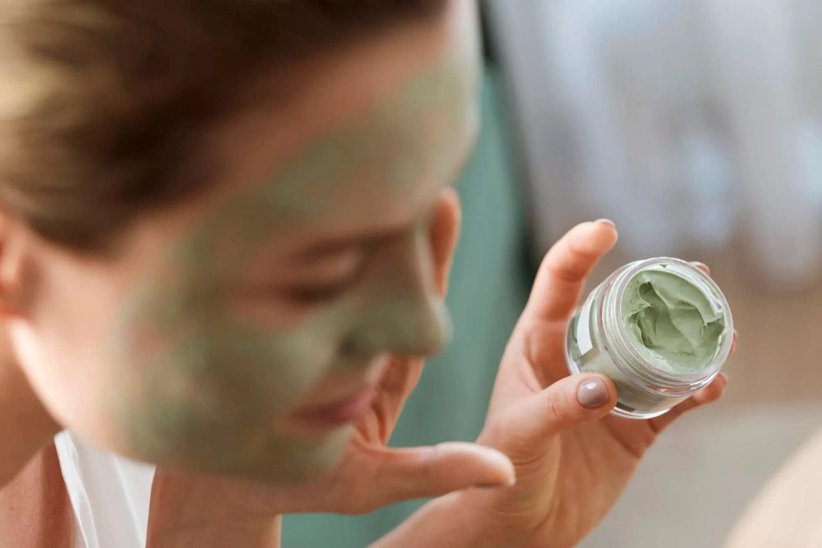 Lady putting hemp seed face mask cream on