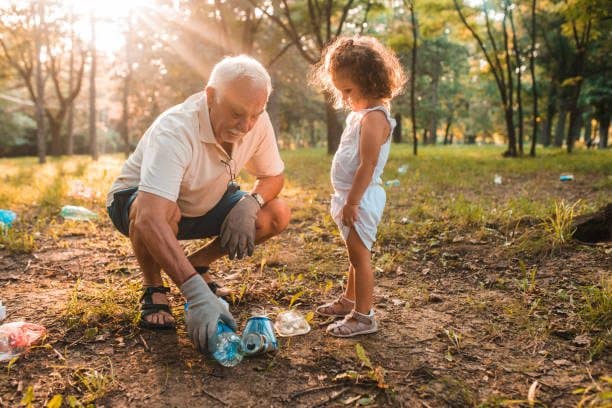 Grandfather and granddaughter picking up water bottles and recycling