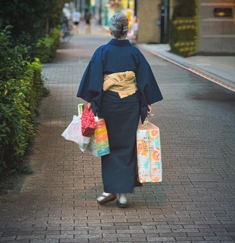 Japanese person walking holding bags